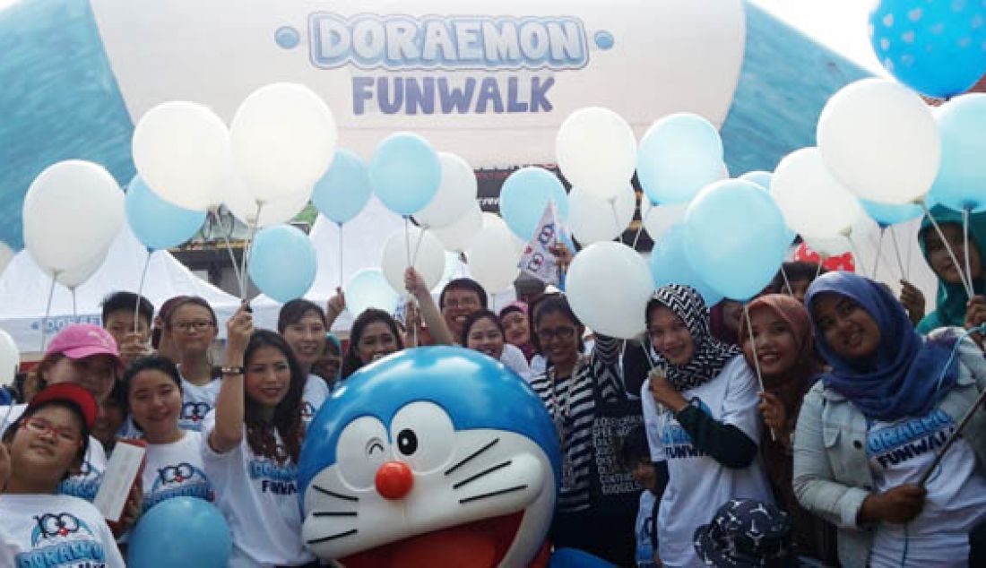 Sebanyak 100 orang berbondong-bondong menggunakan kaos Doraemon dan Baling &acirc;€“ Baling Bambu untuk mengikuti Doraemon Funwalk sekaligus Meet &amp; Greet dengan Robot Biru pemilik Kantong Ajaib di Taman Bungkul, Surabaya, Minggu (20/12). Jalan santai bersama ini menempuh jarak 2,4 km. Foto: Ist - JPNN.com