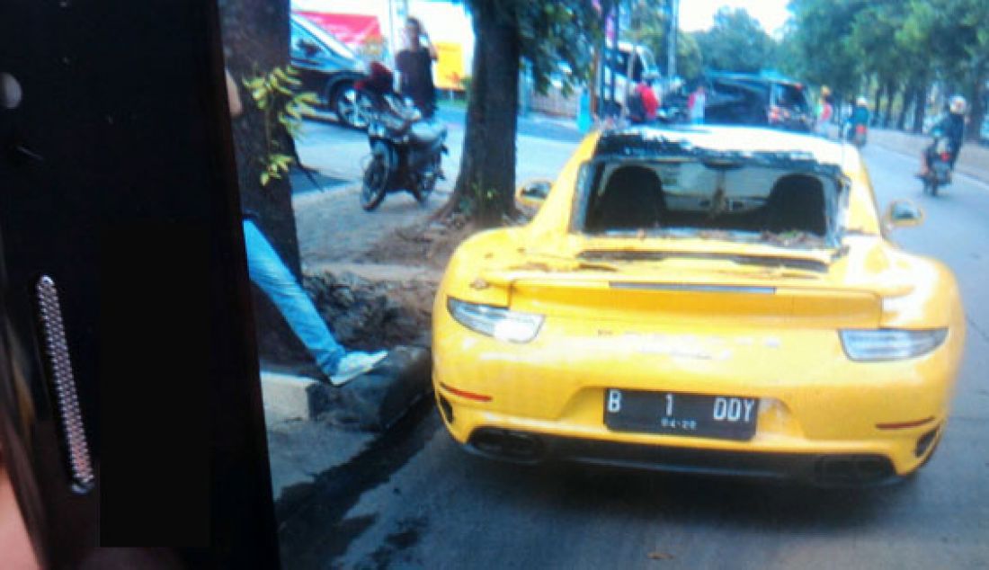 Sebuah sedan mewah jenis Super car berwarna kuning hancur usai tertimpa pohon tumbang di Jalan Sultan Iskandar Muda, tepat di depan toko furnitur Informa, Senin, (21/12) sore. Foto: Ist - JPNN.com