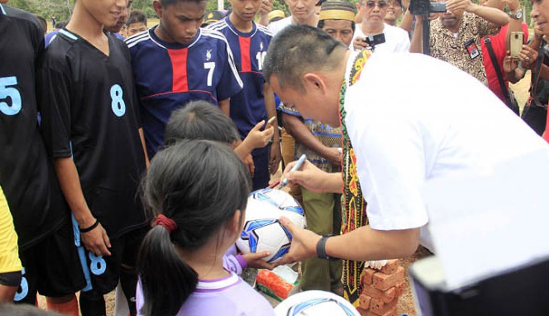 Menpora Imam Nahrawi saat menandatangani bola yang diberikan kepada sejumlah klub sepakbola Kecamatan Samboja, dalam acara peletakkan pertama bantuan lapangan desa di Desa Tani Bhakti, Samboja, Kutai Kertanegara, Jumat (19/8). Foto: Kabiro Humas dan Hukum Kemenpora - JPNN.com