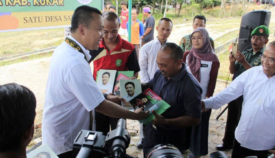 Menpora Imam Nahrawi didampingi Asisten Deputi Standardisasi dan Infrastuktur Olahraga Samsudin menyerahkan voucher bantuan rehabilitasi 1 lapangan 1 desa dan buku-buku karya Menpora di Desa Tani Bhakti, Samboja, Jumat (19/8). Foto: Kabiro Humas dan Hukum Kemenpora - JPNN.com