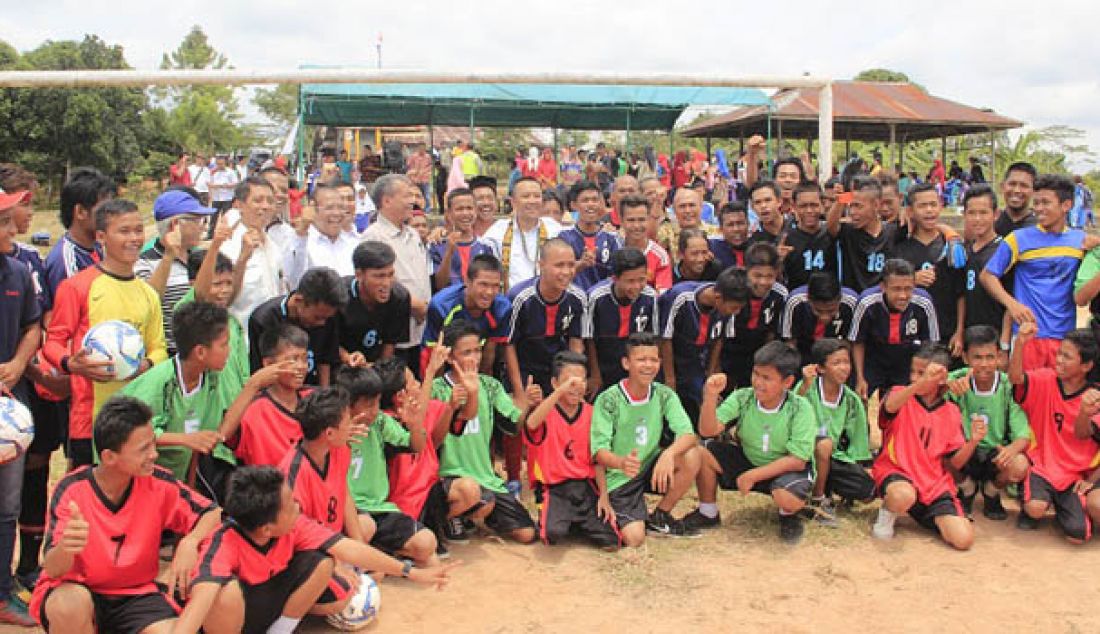 Menpora Imam Nahrawi berfoto bersama para pemain muda sepakbola dari berbagai klub sepakbola di Kecamatan Samboja, usai peletakkan pertama bantuan lapangan desa di Desa Tani Bhakti, Samboja, Kutai Kertanegara, Jumat (19/8). Foto: Kabiro Humas dan Hukum Kemenpora - JPNN.com