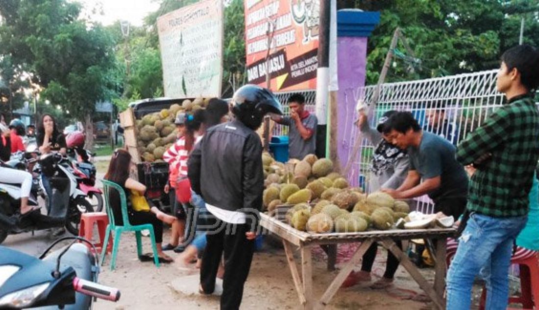 Salah satu pedagang durian di sekitar simpang empat Kelurahan Kayu Bulan, Kecamatan Limboto ramai dikunjungi warga sekitar dan pengguna jalan, Minggu (13/12). Foto: Arief/Gorontalo Post/JPNN.com - JPNN.com