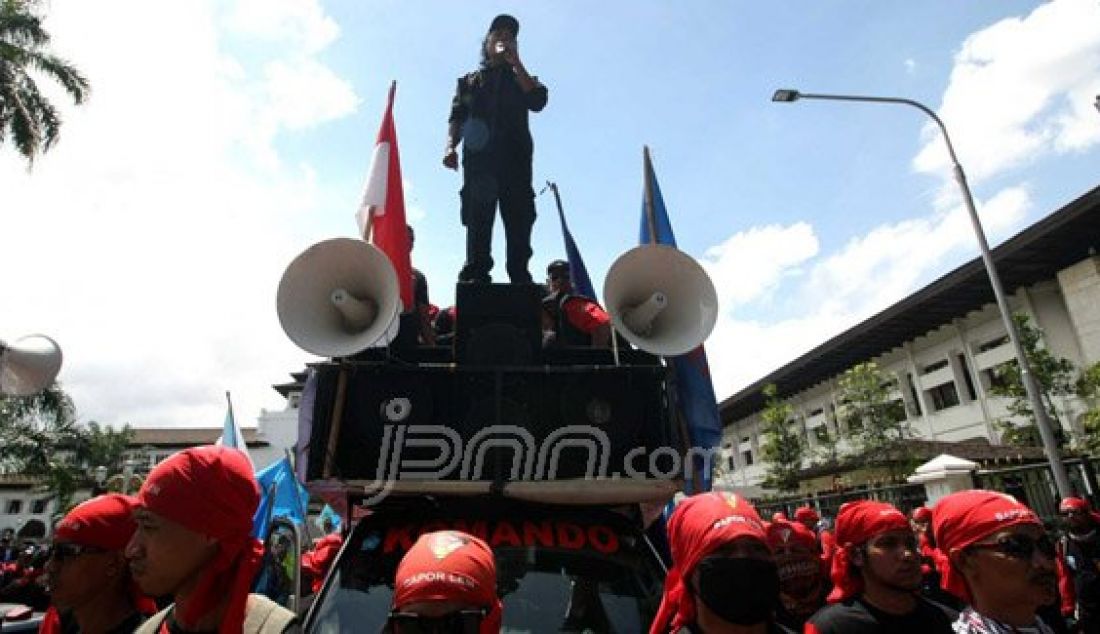 Sejumlah massa buruh dari berbagai organisasi buruh melakukan aksi unjuk rasa di depan Gedung Sate, Kota Bandung, Selasa (15/12). Massa menuntut Gubernur Jawa Barat, Ahmad Heryawan untuk merubah kembali Upah Sektoral berdasarkan rekomendasi Wali Kota. Foto: Khairizal/Radar Bandung/JPNN.com - JPNN.com