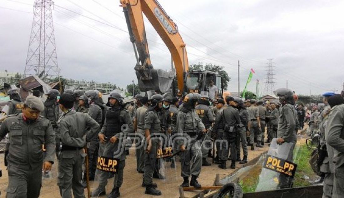 PERSIAPAN: Puluhan petugas Satpol PP bersiap siap untuk mengeksekusi bangunan liar di Jalan Raya Kalimalang, Kabupaten Bekasi, Kamis (17/12). Proses eksekusi tersebut akhrinya berakhir bentrok. Foto: Deny/Indopos/JPNN.com - JPNN.com