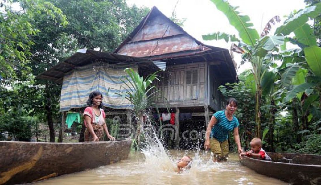 Banjir tidak mengahalangi warga untuk beraktivitas di Kampung Romang Tangaya, Keluarahan Tamangapa, Manggala, Makassar, Sulsel, Senin (21/12). Sepekan terahir kampung tersebut tergenang air hingga lutut orang dewasa. Foto: M Idham/FAJAR/JPNN.com - JPNN.com