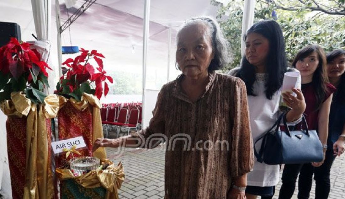 Para Jemaat saat mengambil air suci dan membuat tanda salib sebelum memasuki Altar di Gereja Katedral, Jakarta, Kamis (24/12). Misa malam Natal bertema 'Hidup Bersama Sebagai Keluarga Allah' akan dilaksanakan pukul 17:00, 19:30 dan 22:00. Foto: Ricardo/JPNN.com - JPNN.com