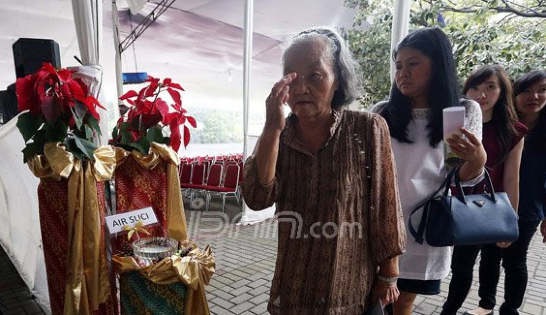 Para Jemaat saat mengambil air suci dan membuat tanda salib sebelum memasuki Altar di Gereja Katedral, Jakarta, Kamis (24/12). Misa malam Natal bertema 'Hidup Bersama Sebagai Keluarga Allah' akan dilaksanakan pukul 17:00, 19:30 dan 22:00. Foto: Ricardo/JPNN.com - JPNN.com