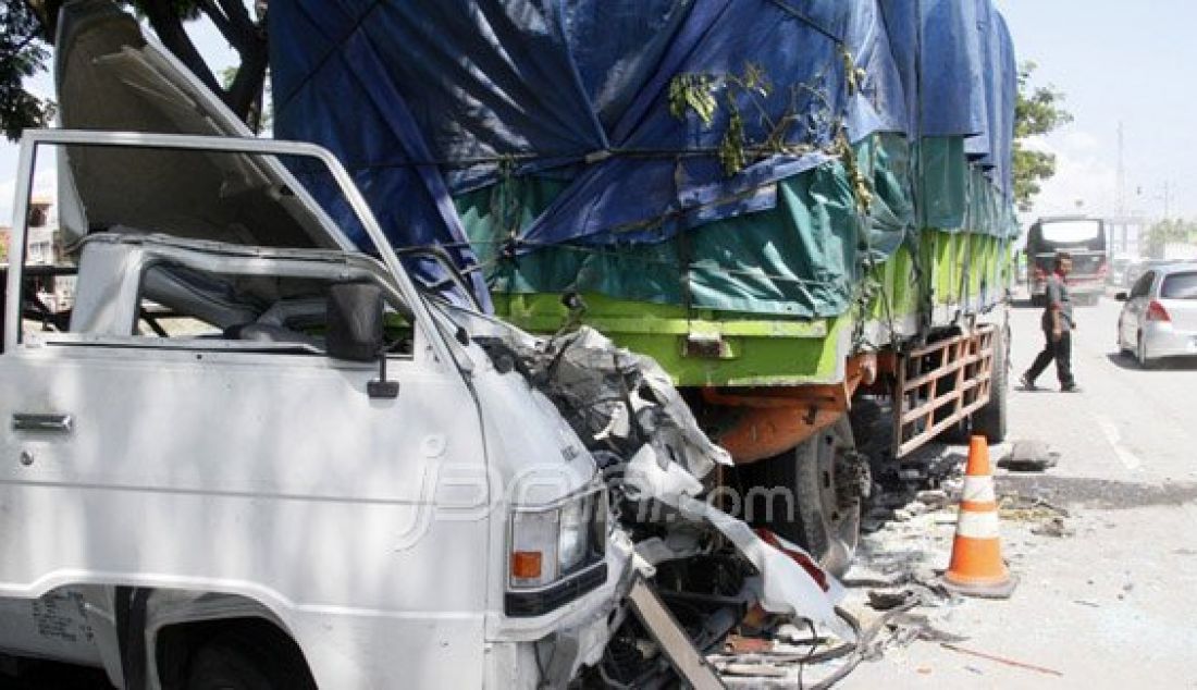 Mobil bak terbuka Nopol AG 9430 AE menyeruduk truk gandeng bermuatan beras yang tengah mengganti roda belakangnya Desa Gajah Kabupaten Demak Jawa Tengah, Jumat (25/12). Kecelakaan tersebut diduga akibat pengemudi yang mengalami kantuk. Foto: Donny/Radar Kudus/JPNN.com - JPNN.com