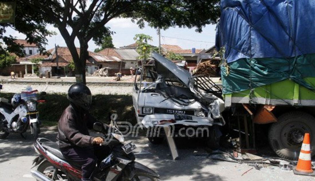 Mobil bak terbuka Nopol AG 9430 AE menyeruduk truk gandeng bermuatan beras yang tengah mengganti roda belakangnya Desa Gajah Kabupaten Demak Jawa Tengah, Jumat (25/12). Kecelakaan tersebut diduga akibat pengemudi yang mengalami kantuk. Foto: Donny/Radar Kudus/JPNN.com - JPNN.com