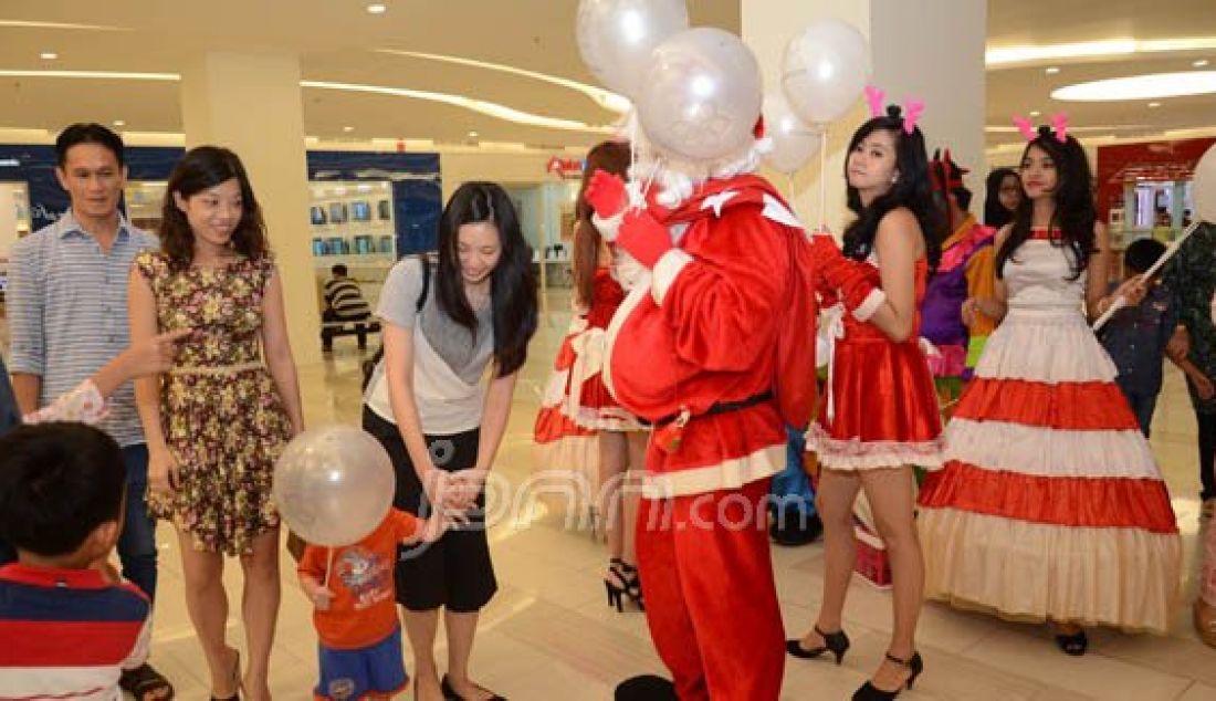 Santa CLaus berkeliling membagikan hadiah kepada sejumlah anak yang berdada di Mall Palembang Icon, Palembang, Jumat (25/12). Foto: Irwansyah/Sumatera Ekspres/JPNN.com - JPNN.com