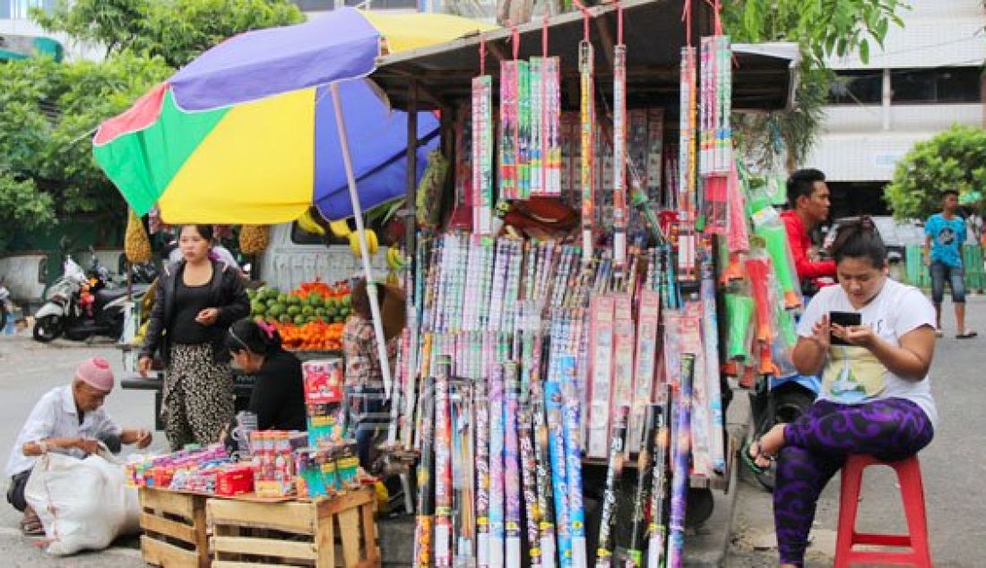 Menjelang Tahun Baru 2016, pedagang petasan mulai menjajakan berbagai macam petasan dan pernak-pernik untuk memeriahkan malam pergantian tahun. Seperti yang terlihat pada Senin (28/12), pedagang tampak berjualan petasan di depan Pasar Klandasan Balikpapan. Foto: Anggi/Kaltim Post/JPNN.com - JPNN.com