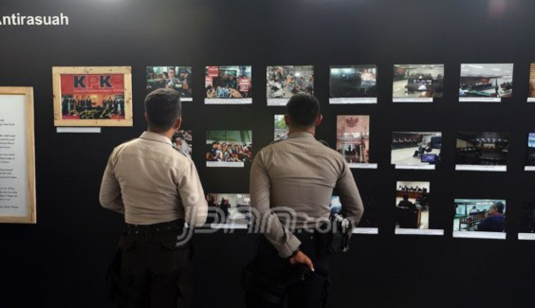 Petugas kepolisian disela istirahat melihat pameran photo KPK yang bertema Mata Selular Antirasuah di Gedung KPK, Jakarta, Selasa (29/12). Pameran tersebut memperingati 12 Tahun KPK. Foto: Ricardo/JPNN.com - JPNN.com