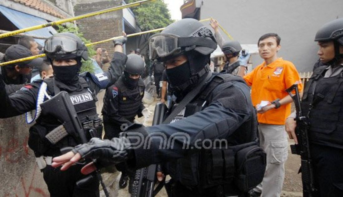 GELEDAH : Sejumlah anggota Densus 88 saat menggeledah rumah terduga teroris jaringan Solo dan teror Bekasi di Jalan Mengger Kota Bandung, Minggu (10/1). Foto: Ramdhani/Radar Bandung/JPNN.com - JPNN.com