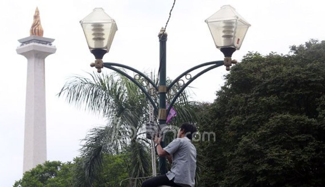 Petugas memperbaiki lampu penerangan di kawasan Tugu Monas, Jakarta, Senin (11/1). Gubernur DKI Jakarta Basuki Tjahaja Purnama memerintahkan Kantor Pengelola Kawasan (KPK) Monas untuk memasang ribuan lampu di kawasan Monas seperti di Singapura dengan kisaran anggaran Rp 35 miliar. Foto: Ricardo/JPNN.com - JPNN.com