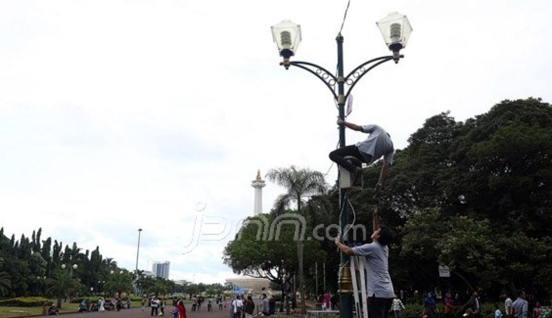 Petugas memperbaiki lampu penerangan di kawasan Tugu Monas, Jakarta, Senin (11/1). Gubernur DKI Jakarta Basuki Tjahaja Purnama memerintahkan Kantor Pengelola Kawasan (KPK) Monas untuk memasang ribuan lampu di kawasan Monas seperti di Singapura dengan kisaran anggaran Rp 35 miliar. Foto: Ricardo/JPNN.com - JPNN.com