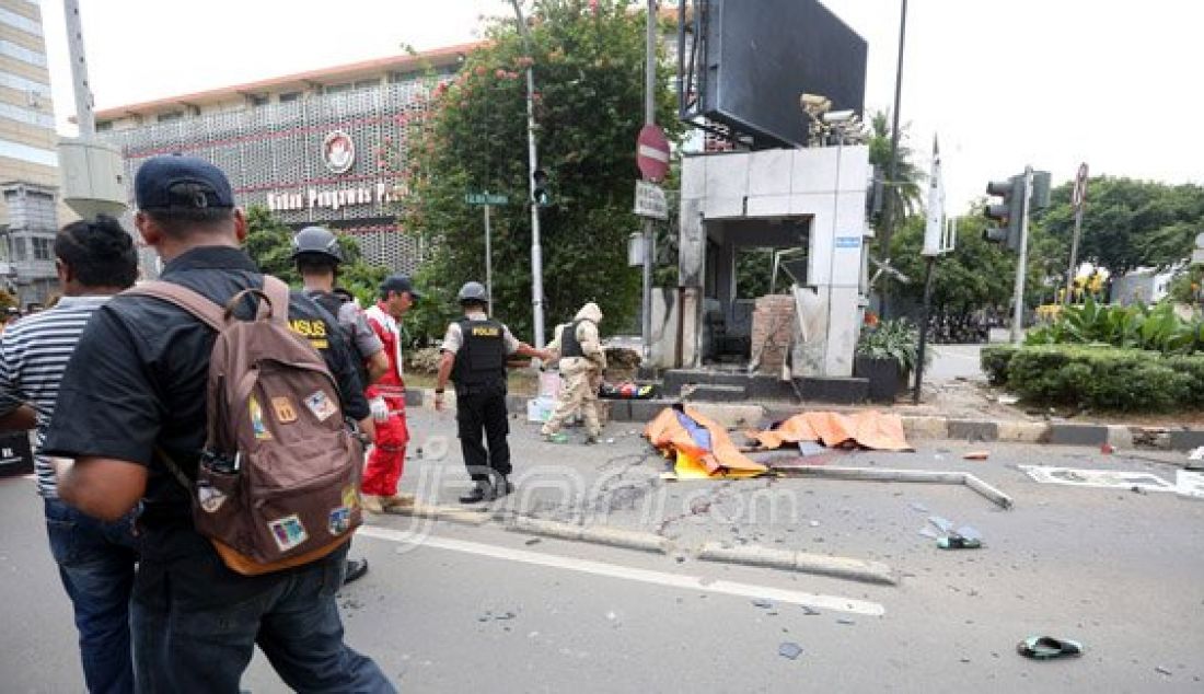 Petugas kepolisian saat mengevakuasi korban ledakan bom di Pos Polisi Sarinah, Jakarta, Kamis (14/1). Sejumlah teroris melakukan penyerangan terhadap beberapa gedung dan pos polisi di kawasan Sarinah yang mengakibatkan sejumlah korban tewas dan luka-luka. Foto: Ricardo/JPNN.com - JPNN.com