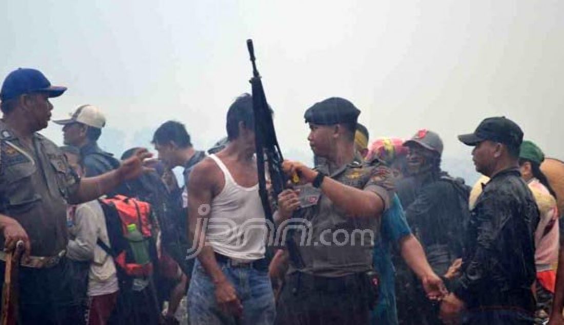 Polisi dan TNI mencoba menenangkan warga Mempawah yang mengusir Eks Gafatar di Camp Moton secara anarkis, Selasa (19/1). Foto: Ocsya/Rakyat Kalbar /JPNN.com - JPNN.com