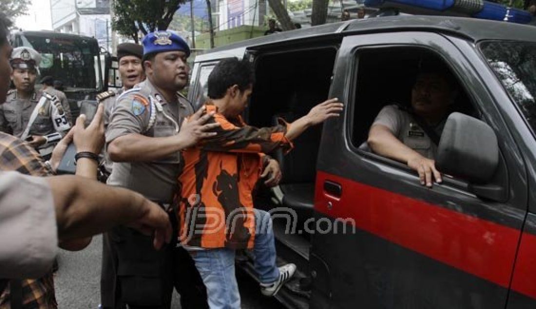 Petugas kepolisian mengamankan seorang kader Pemuda Pancasila yang membawa senjata tajam setelah dilakukan pemeriksan, ketika akan menghadiri acara pelantikan MPC PP di Lapangan Benteng Medan, Minggu (31/1). Foto: Danil/Sumut Pos/JPNN.com - JPNN.com