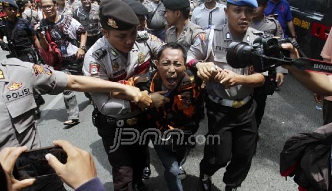 Petugas kepolisian mengamankan seorang kader Pemuda Pancasila yang membawa paket sabu setelah dilakukan pemeriksan, ketika akan menghadiri acara pelantikan MPC PP di Lapangan Benteng Medan, Minggu (31/1). Foto: Danil/Sumut Pos/JPNN.com - JPNN.com