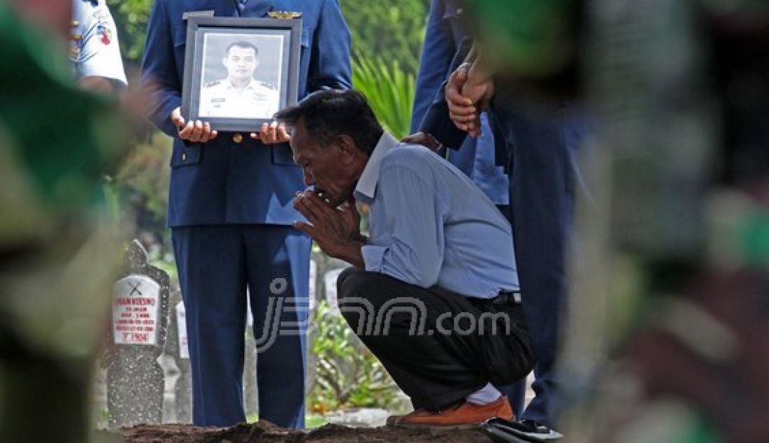 Faizol Rozy, ayah almarhum Mayor Pnb Ivy Safatillah, berdoa di dekat liang lahat di sela prosesi pemakaman secara militer di Taman Makam Pahlawan (TMP) Kusumanegara, Jogjakarta, Kamis (11/2). Foto: Guntur/Radar Jogja/JPNN.com - JPNN.com