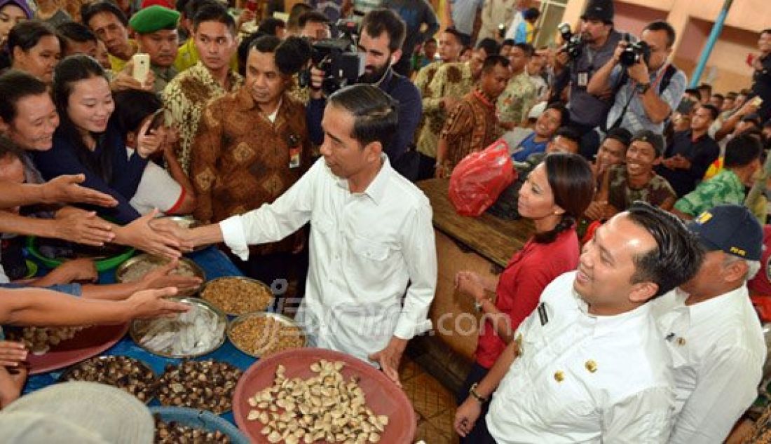 Gubernur Lampung M Ridho Ficardo (kanan) mendampingi Presiden Joko Widodo (Jokowi) dan rombongan mengunjungi Pasar Gudang Lelang, Telukbetung, Bandar Lampung, Kamis, (11/2). Sesampai di sana Kepala Negara menyapa dan menyalami para pedagang dan pengunjung. Foto: Tegar/Radar Lampung/JPNN.com - JPNN.com