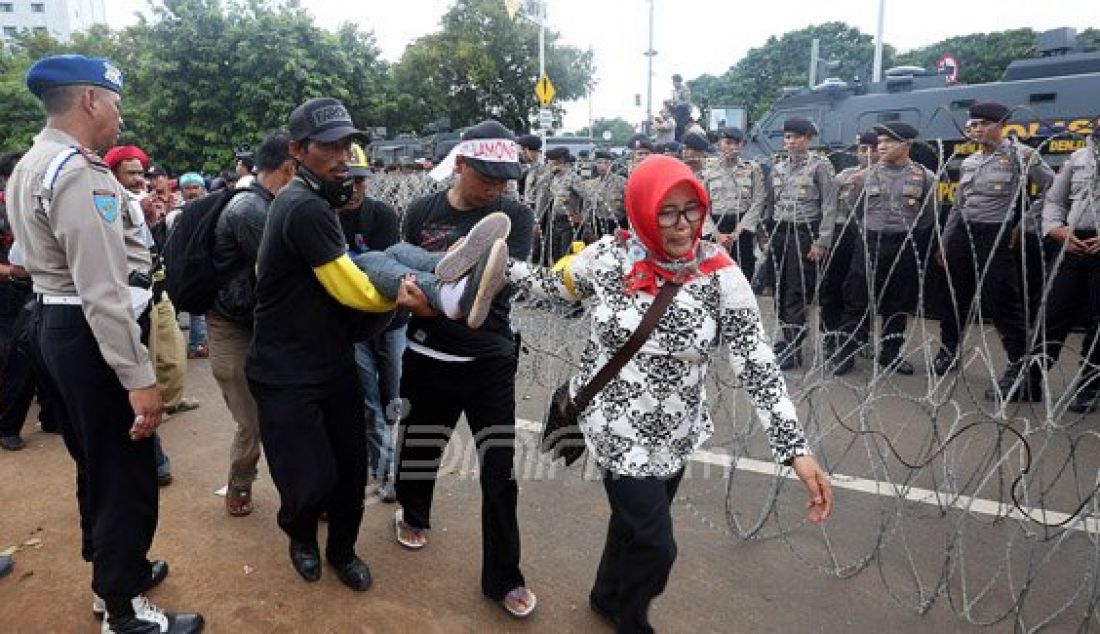 Honorer K2 pingsan saat melakukan aksi unjukrasa di hari ke-3 di depan Istana Merdeka, Jakarta, Jumat (12/2). Mereka meminta presiden Jokowi mengangkat honorer K2 menjadi PNS. Foto: Ricardo/JPNN.com - JPNN.com