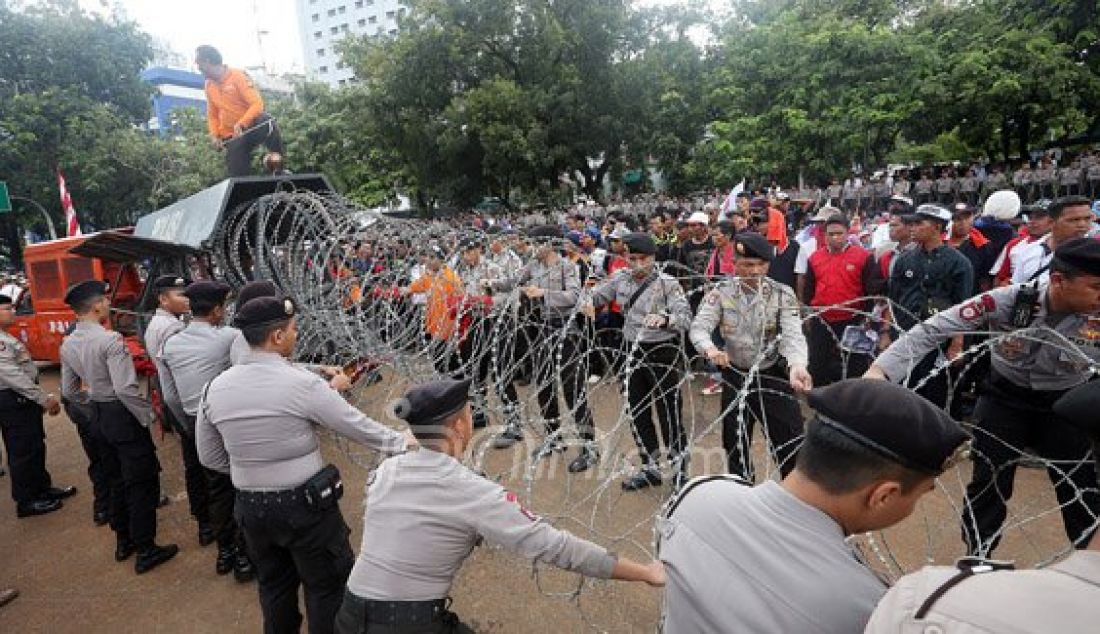Petugas gabungan Polda Metro Jaya dan Polres Jakarta Pusat saat merapihkan kawat berduri pada demo Honorer K2 yang masih berlangsung di depan Istana Merdeka, Jakarta, Jumat (12/2). Foto: Ricardo/JPNN.com - JPNN.com