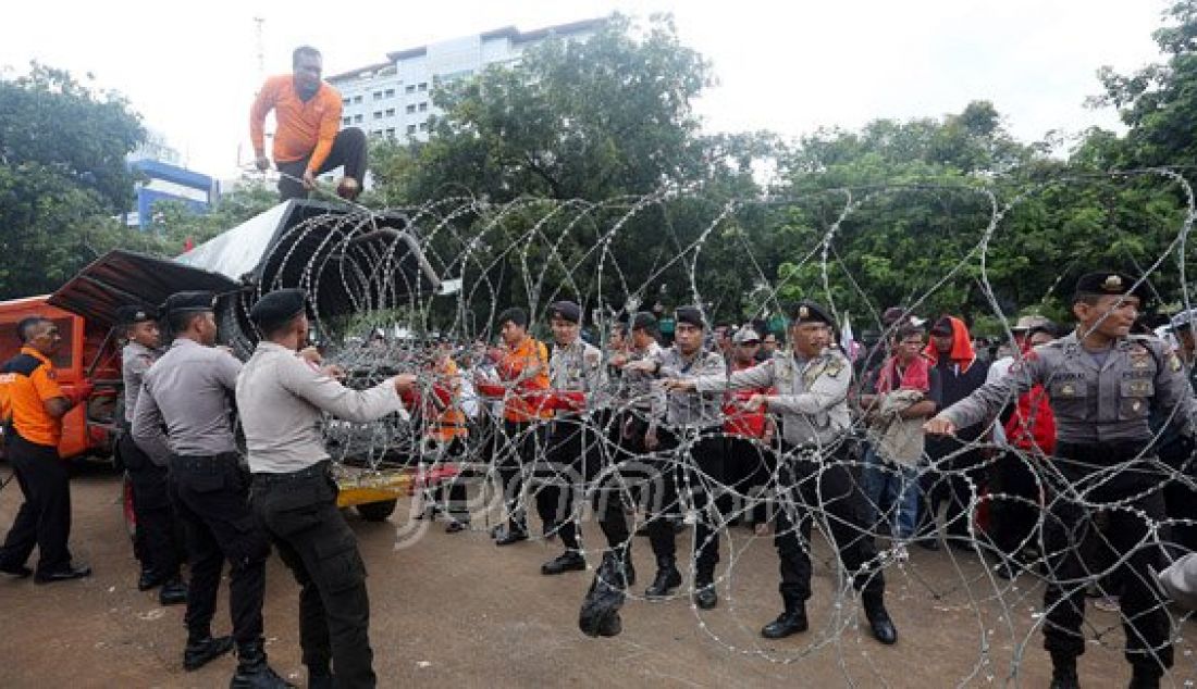 Petugas gabungan Polda Metro Jaya dan Polres Jakarta Pusat saat merapihkan kawat berduri pada demo Honorer K2 yang masih berlangsung di depan Istana Merdeka, Jakarta, Jumat (12/2). Foto: Ricardo/JPNN.com - JPNN.com