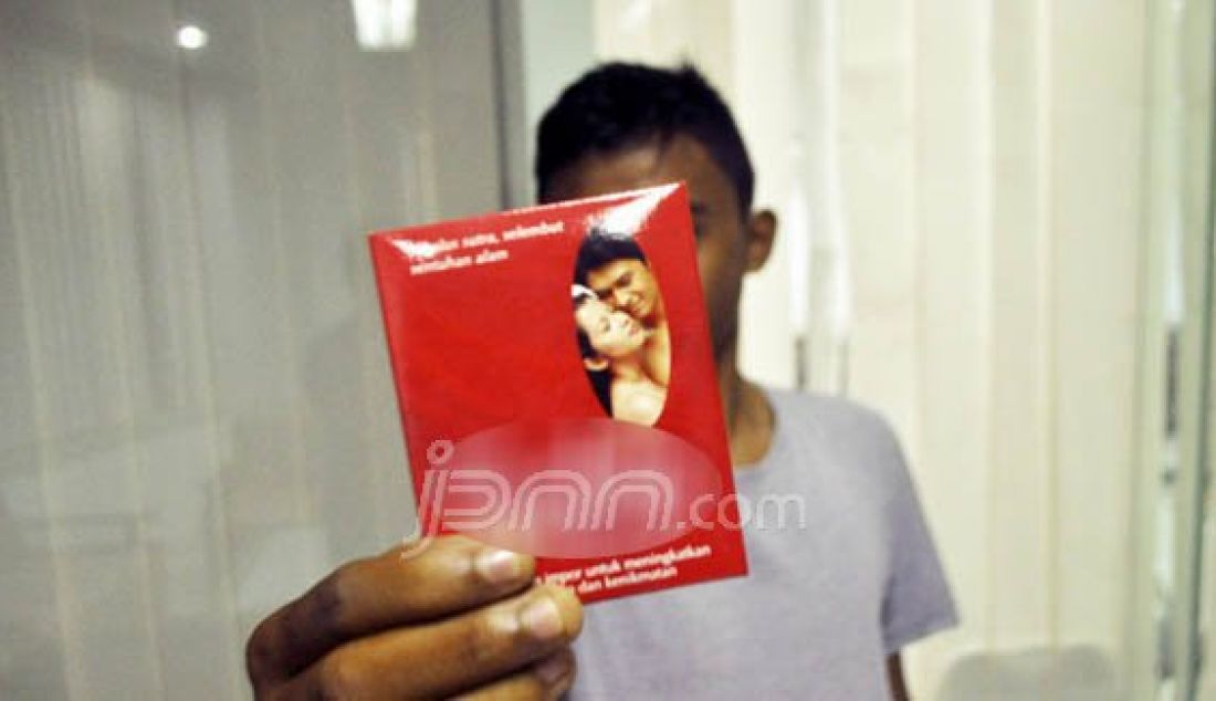 BUKAN IKLAN: Salah seorang remaja menunjukan kondom yang baru saja dibelinya pada perayaan hari Valentine, Minggu (14/2). Foto: Agung/Radar Sulteng/JPNN.com - JPNN.com