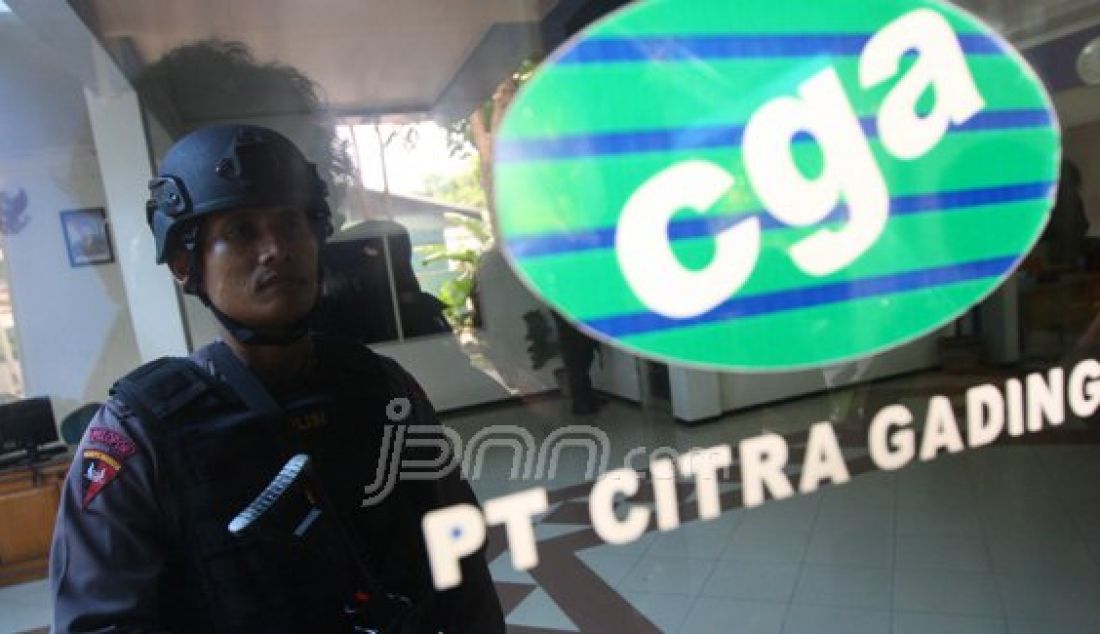 Anggota Kepolisian berjaga saat tim KPK melakukan pemeriksaan di salah satu kantor CGA yang berada di Gayungkebonsari Manunggal Surabaya, (16/2). Foto: Dipta/Jawa Pos/JPNN.com - JPNN.com