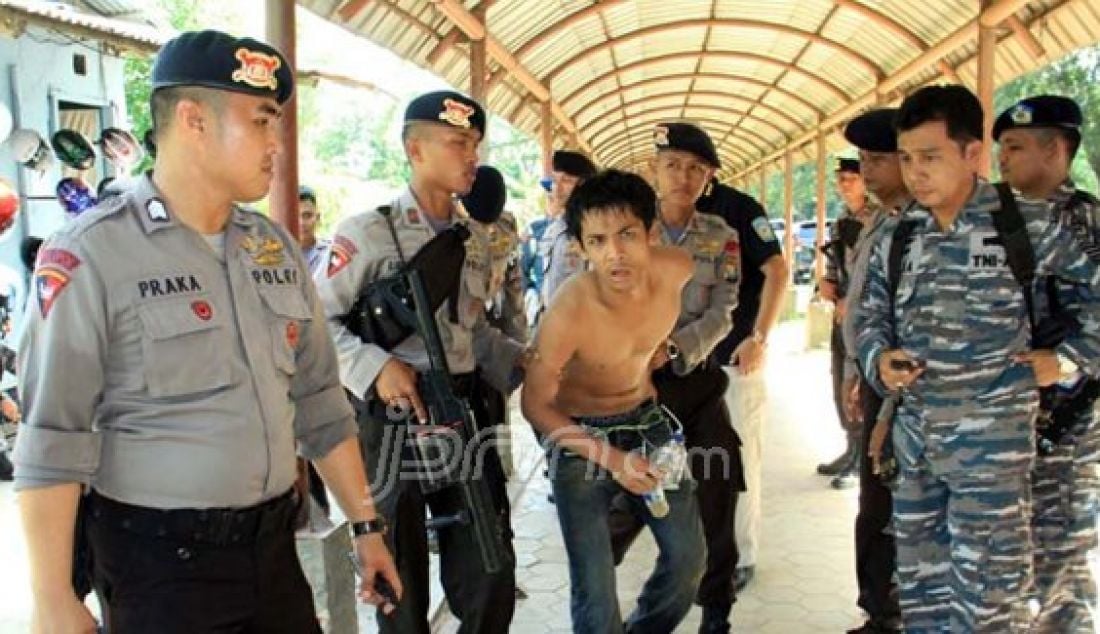 Polisi dan TNI mengamankan seorang pengguna narkoba di Kampung Aceh, Simpangdam, Seibeduk, Selasa (16/2). Pelaku sempat berusaha kabur, namun pihak kepolisian berhasil mengejarnya dibantu oleh aparat TNI. Foto: Dalil/Batam Pos/JPNN.com - JPNN.com