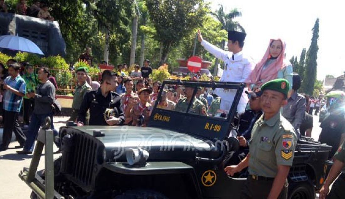 Wakil Bupati Trenggalek Nur Arifin bersama istrinya Novita Herdiani naik mobil jeep perang saat diarak ke pendopo Trenggalek, Jumat (19/2). Foto: Thomas/JPNN.com - JPNN.com