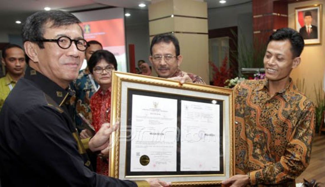 Menkum HAM Yasonna H Laoly saat memberikan sertifikat pendaftaran merek pesawat televisi buatan Muhammad Kusrin pada peresmian layanan terpadu kekayaan intelektual di Gedung Direktorat Kekayaan Intelektual, Kemenkum HAM, Jakarta, Kamis (25/2). Foto: Miftahul/Jawa Pos/JPNN.com - JPNN.com