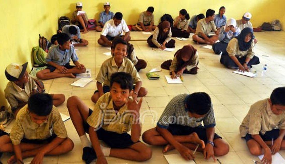 Sejumlah siswa di SMP Negeri 16 Tawaeli, kota Palu terpaksa harus belajar dengan kondisi melantai, Sabtu (27/1). Hal tersebut dikarenakan gedung baru yang mereka tempati belum mendapat bantuan bangku dan kursi dari pemerintah dan baru akan terealisasi pada tahun ini. Foto: Agung/Radar Sulteng/JPNN.com - JPNN.com