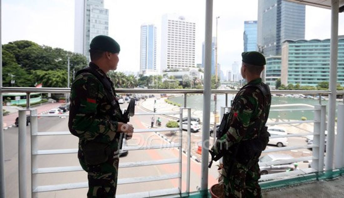 Personil TNI AD saat berjaga di Atas Jembatan Penyebrangan Orang (JPO) Bundaran HI, Jakarta, Sabtu (5/3). Penjagaan pusat kota diperketat menjelang pelaksanaan Konferensi Tingkat Tinggi Luar Biasa Organisasi Konferensi Islam (OKI) selama dua hari di JCC Senayan pada 6-7 Maret. Foto: Ricardo/JPNN.com - JPNN.com