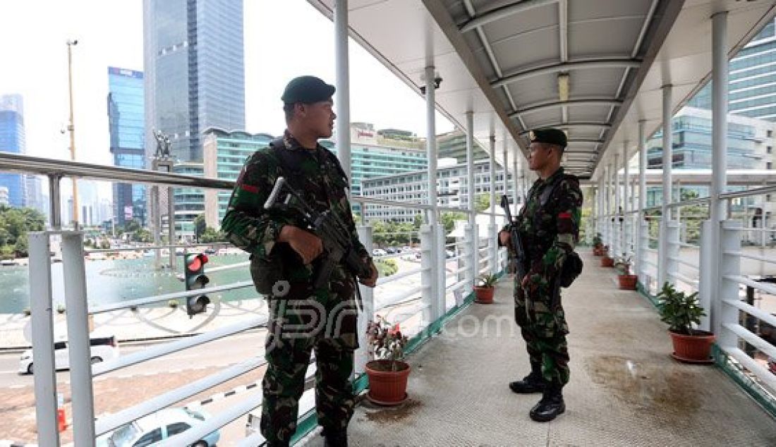 Personil TNI AD saat berjaga di Atas Jembatan Penyebrangan Orang (JPO) Bundaran HI, Jakarta, Sabtu (5/3). Penjagaan pusat kota diperketat menjelang pelaksanaan Konferensi Tingkat Tinggi Luar Biasa Organisasi Konferensi Islam (OKI) selama dua hari di JCC Senayan pada 6-7 Maret. Foto: Ricardo/JPNN.com - JPNN.com