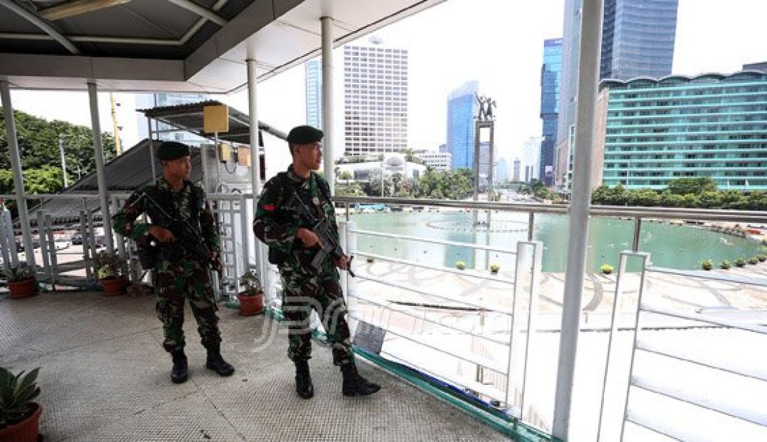 Personil TNI AD saat berjaga di Atas Jembatan Penyebrangan Orang (JPO) Bundaran HI, Jakarta, Sabtu (5/3). Penjagaan pusat kota diperketat menjelang pelaksanaan Konferensi Tingkat Tinggi Luar Biasa Organisasi Konferensi Islam (OKI) selama dua hari di JCC Senayan pada 6-7 Maret. Foto: Ricardo/JPNN.com - JPNN.com