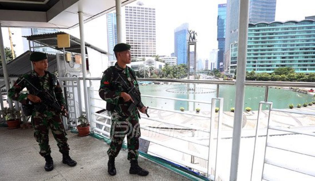 Personil TNI AD saat berjaga di Atas Jembatan Penyebrangan Orang (JPO) Bundaran HI, Jakarta, Sabtu (5/3). Penjagaan pusat kota diperketat menjelang pelaksanaan Konferensi Tingkat Tinggi Luar Biasa Organisasi Konferensi Islam (OKI) selama dua hari di JCC Senayan pada 6-7 Maret. Foto: Ricardo/JPNN.com - JPNN.com