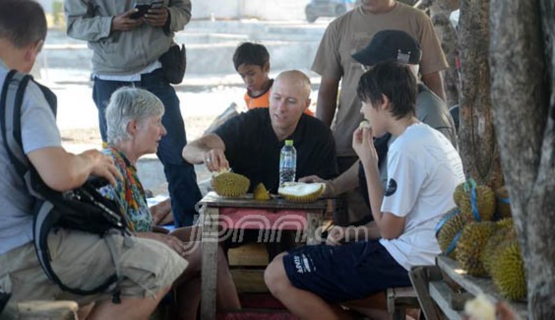 MAKAN DURIAN: Ratusan Turis mulai kepung kota Ternate, Senin (7/3). Terlihat beberapa turis sedang menikmati duren dikawasan reklamasi tapak II Ternate. Foto: Erwin/malut Pos/JPNN.com - JPNN.com