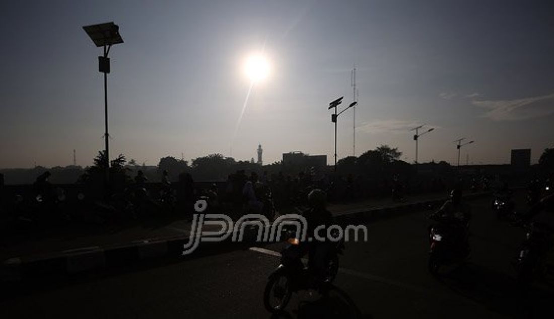 Warga saat menyaksikan fenomena alam Gerhana Matahari di Banjir Kanal Timur (BKT), Jakarta Timur, Rabu (9/3). Fenomena alam Gerhana Matahari di Jakarta terjadi 88%. Foto: Ricardo/JPNN.com - JPNN.com