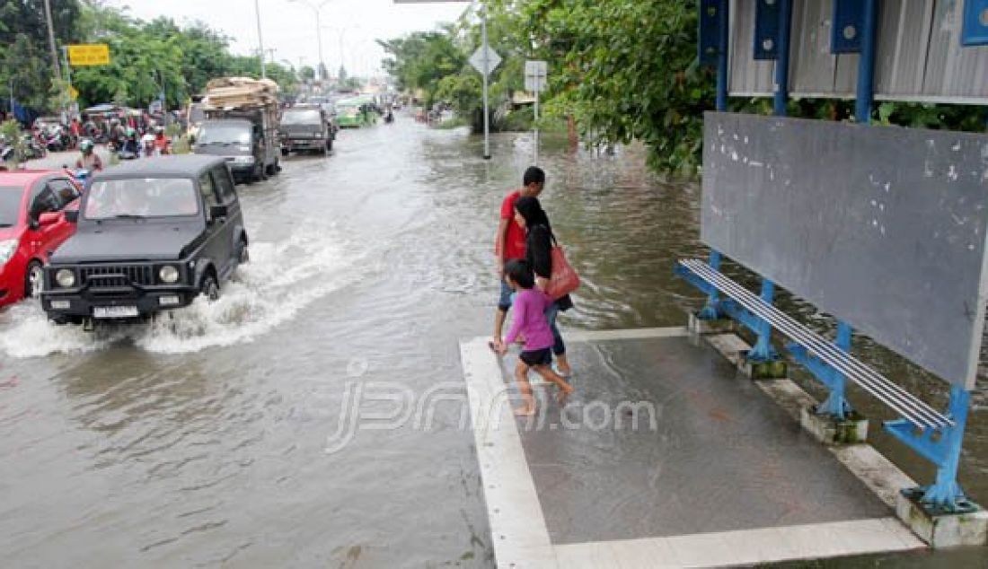 Kendaraan melintasi banjir di jalan HR Soebrantas, Pekanbaru, Riau, Selasa (22/3). Hujan yang mengguyur kota Pekanbaru membuat jalan Hr Soebrantas terendam air dikarenaka tidak maksimal nya drainase. Foto: Akhwan/Riau Pos/JPNN.com - JPNN.com