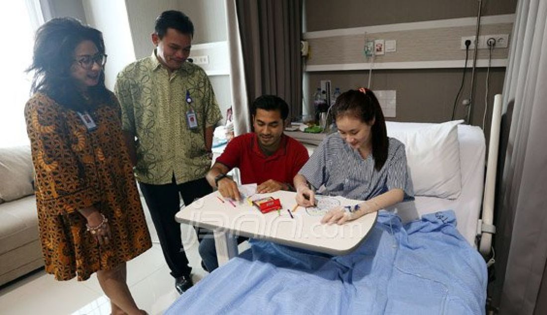 Dokter membimbing seorang anak untuk mewarnai gambar telur Paskah saat menjalani rawat inap di RS Siloam Simatupang, Jakarta Selatan, Minggu (27/3). Kegiatan mewarnai telur untuk menghibur pasien bertema &quot;Stress Relief&quot; ini merupakan program Inisiatif Pasien-Sentris guna membantu pemulihan. Foto : Ricardo/JPNN.com - JPNN.com