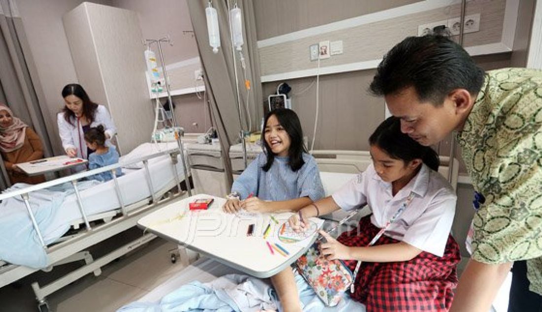 Dokter membimbing seorang anak untuk mewarnai gambar telur Paskah saat menjalani rawat inap di RS Siloam Simatupang, Jakarta Selatan, Minggu (27/3). Kegiatan mewarnai telur untuk menghibur pasien bertema &quot;Stress Relief&quot; ini merupakan program Inisiatif Pasien-Sentris guna membantu pemulihan. Foto : Ricardo/JPNN.com - JPNN.com