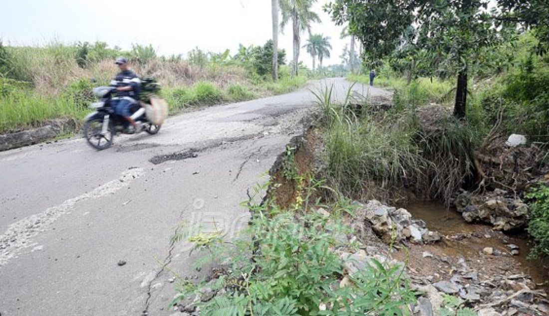 Pengendara melintasi jalan rusak dan bergelombang di Jalan Babakan Sirkuit, Hambalang, Bogor, Selasa (29/3). Curah hujan yang tinggi membuat sejumlah ruas jalan tersebut rawan longsor dan dikhawatirkan dapat membahayakan pengguna jalan yang melintas. Foto: Ricardo/JPNN.com - JPNN.com