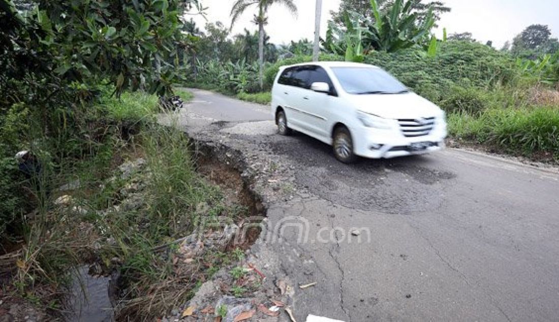 Pengendara melintasi jalan rusak dan bergelombang di Jalan Babakan Sirkuit, Hambalang, Bogor, Selasa (29/3). Curah hujan yang tinggi membuat sejumlah ruas jalan tersebut rawan longsor dan dikhawatirkan dapat membahayakan pengguna jalan yang melintas. Foto: Ricardo/JPNN.com - JPNN.com