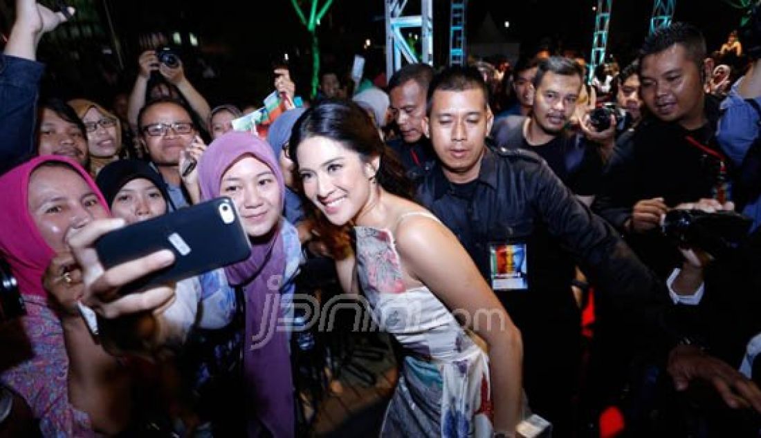 WEFIE: Dian Sastro melayani permintaan penggemar untuk foto bareng saat gala premier film AADC2 di kota Yogyakarta, Minggu (24/4). Foto: Abraham/Radar Jogja/JPNN.com - JPNN.com