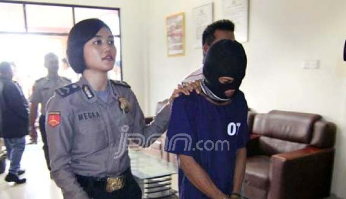 Anggota Polsek Bengkong, Bripda Mega menggiring AK, tersangka pencabulan terhadap anak kandungnya sendiri, Senin (2/5). Foto: Dalil/Batam Pos/JPNN.com - JPNN.com