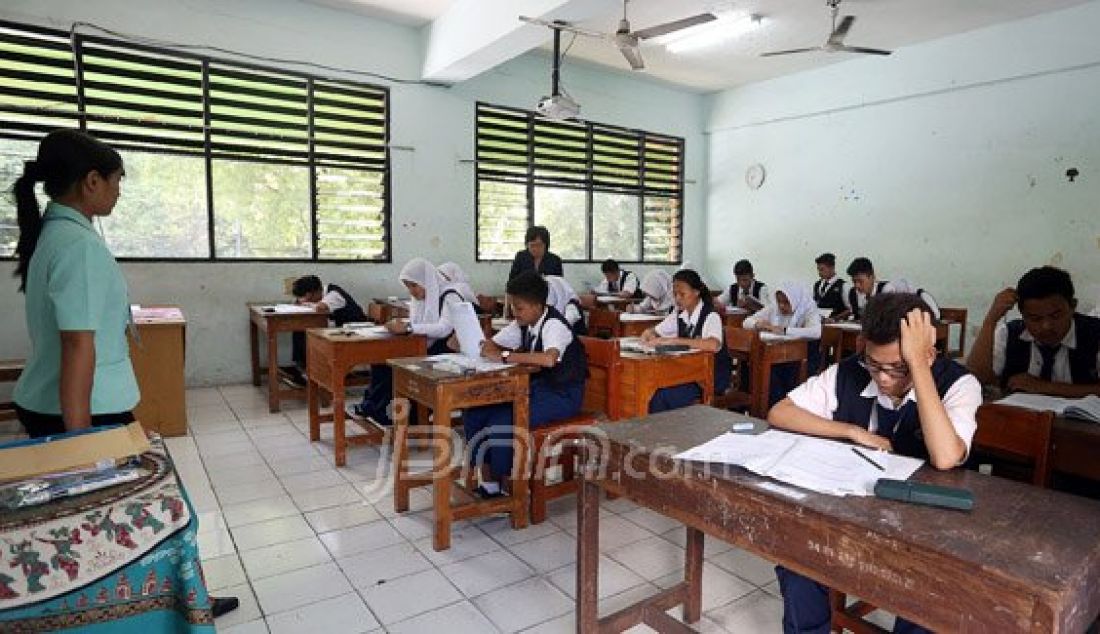 Siswa-siswi SMPN 4 Jakarta saat mengikuti Ujian Nasional, Jakarta, Senin (9/5). Pihak sekolah dan siswa optimis UN 2016 akan berjalan dengan lancar. Foto: Ricardo/JPNN.com - JPNN.com