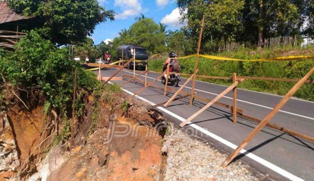 Warga memberi tanda di lokasi jurang yang longsor di pinggir jalan Desa Kayuara, Kecamatan Mandor, Rabu (11/5). Foto: Antonius/Rakyat Kalbar/JPNN.com - JPNN.com