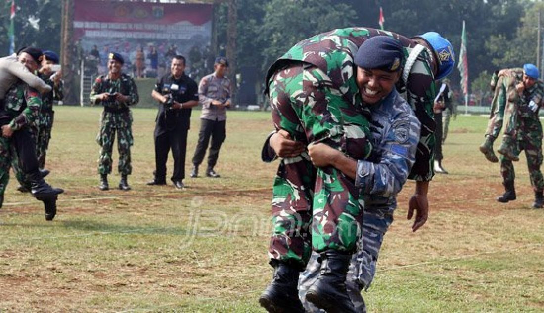 Aparat gabungan TNI, Polda Metro Jaya, Pemprov DKI Jakarta, Ormas dan Mahasiswa saat mengikuti lomba tarik tambang dan gendong di lapangan Brigif Para Raider 17 Cijantung, Jakarta Timur, Selasa (17/5). Apel bersama ini rutin dilakukan untuk meningkatkan sinergi dalam mengamankan wilayah Ibu Kota. Foto: Ricardo/JPNN.com - JPNN.com